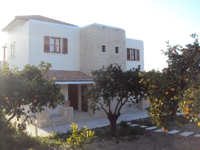 Completed two-storey Cypriot residence with rendered walls, stone detailing and timber shutters